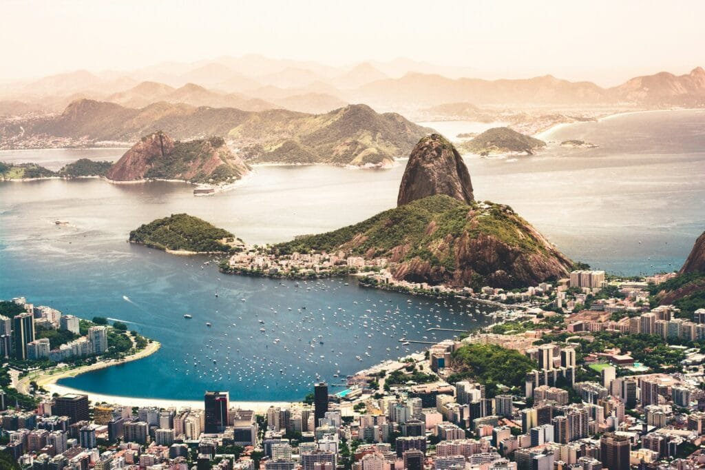 Vista aérea do Rio de Janeiro com o Pão de Açúcar, a Baía de Guanabara e os prédios da Zona Sul